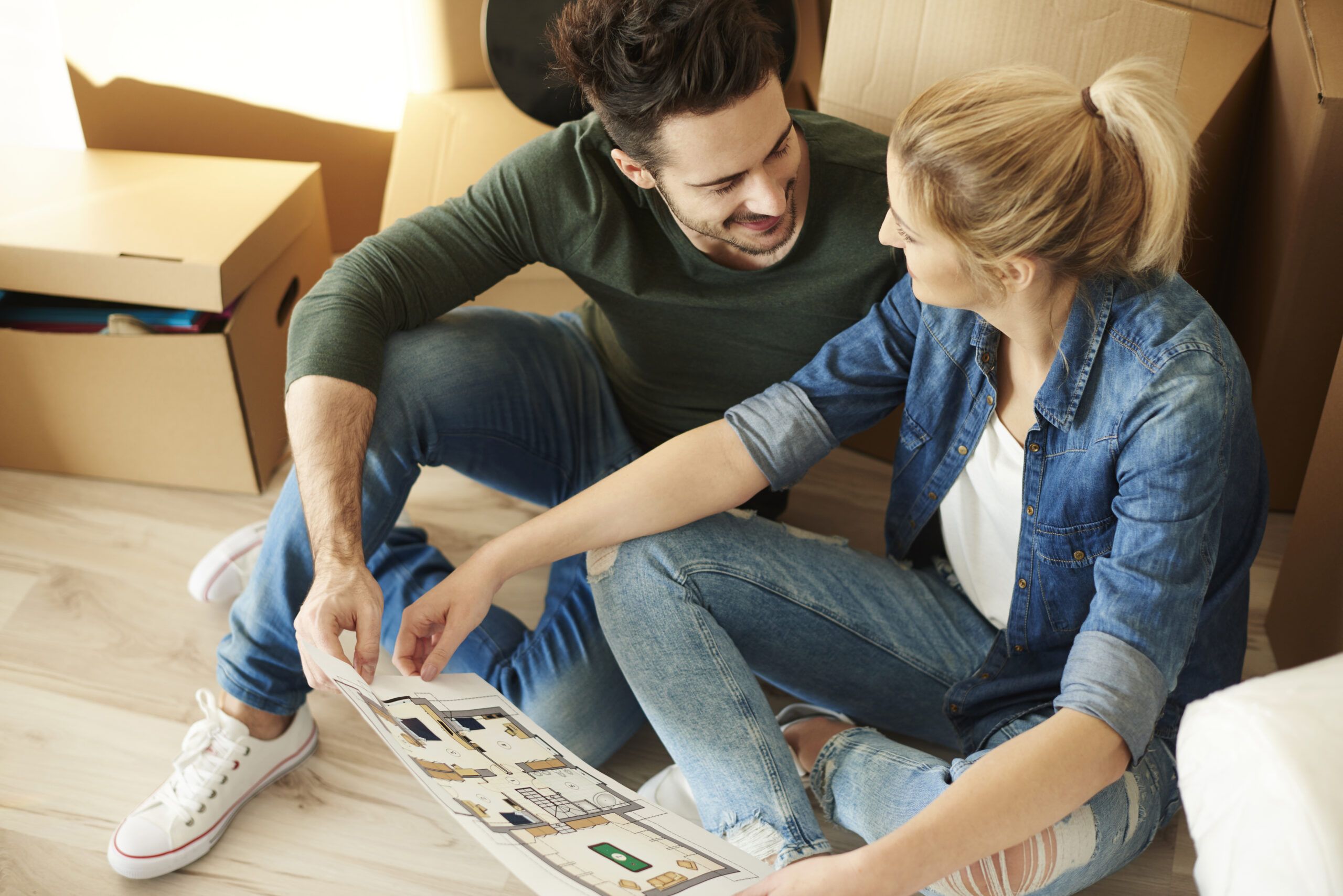 Couple sitting on the floor with blueprint